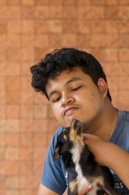 Chihuahua köpeği olan Asyalı bir adam.