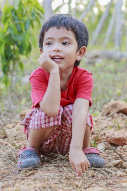 Mutlu Asyalı küçük çocuğun portresi açık havada gülümsüyor