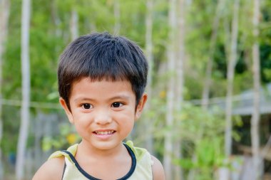 Kapalı alanda gülümseyen Asyalı küçük çocuğun şirin portresi.