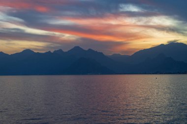 Gün batımında açık renkli gökyüzü ve Antalya 'da dağlar. Türkiye.