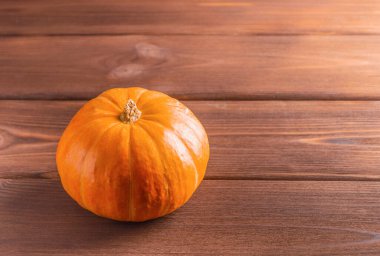 Ahşap arka planda parlak olgun bir balkabağı. Boşluğu kopyala.