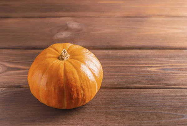 Ahşap arka planda parlak olgun bir balkabağı. Boşluğu kopyala.