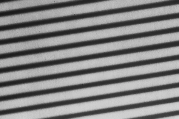 Venetian blinds shadows on wall, light through blinds on wall background — Stockfoto