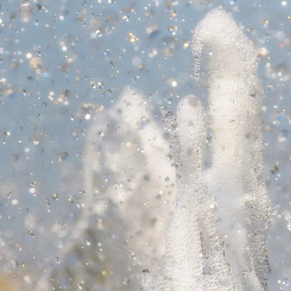 Abstrakte Wasserspritzer Hintergrund, Wassertropfen auf blauem Himmel Hintergrund — Stockfoto