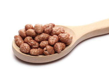 Beyaz arka planda izole edilmiş tahta kaşıkta yer fıstığı yığını.