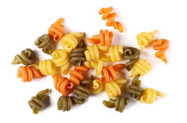 Çöl buğdayından yapılmış, beyaz zemin üzerinde pişirilmemiş üç renkli makarna yığını, üst görünüm