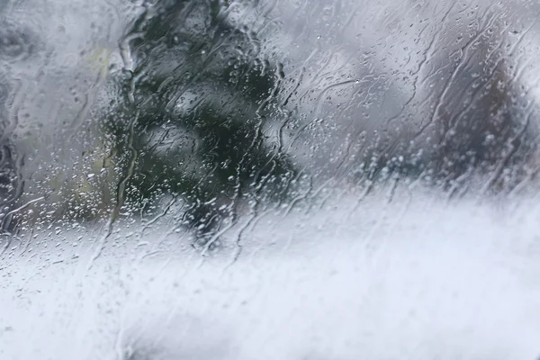 Vista de estrada através da janela do carro frontal com flocos de neve derretidos e geada, vista artística — Fotografia de Stock