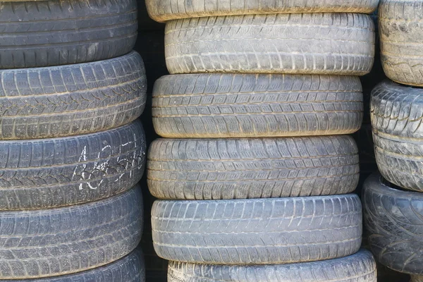 Viejos neumáticos usados apilados fondo — Foto de Stock