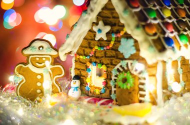 Işıkları ve kardan adamı olan zencefilli ekmek evi.