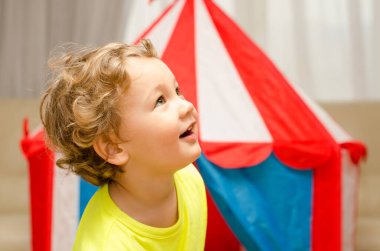 Küçük çocuk evde sirkle oynuyor.