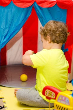 Küçük çocuk evde sirkle oynuyor.
