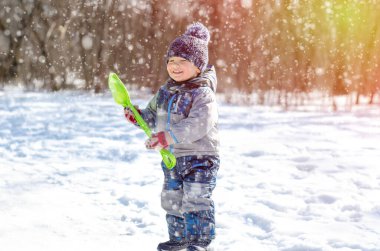 Küçük çocuk kış parkında yürüyor.