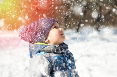 Küçük çocuk kış parkında yürüyor.