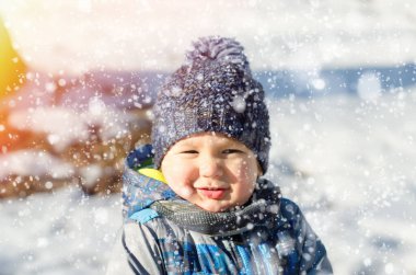 Küçük çocuk kış parkında yürüyor.