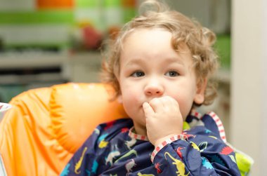 Küçük çocuk evde yemek yiyor.