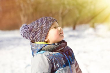 Küçük çocuk kış parkında yürüyor.