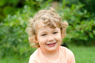 Dışarıdaki gülümseyen küçük çocuğun portresi.