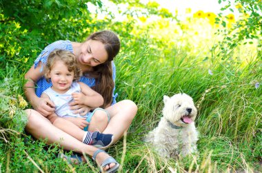 Anne ve çocuk çimenlerde oturuyor.