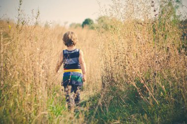 Kırsal alanda yürüyen küçük bir çocuk