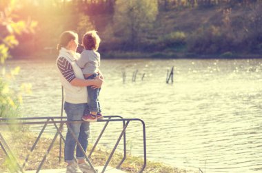 Anne ve çocuk güzel gölün yanında duruyor.