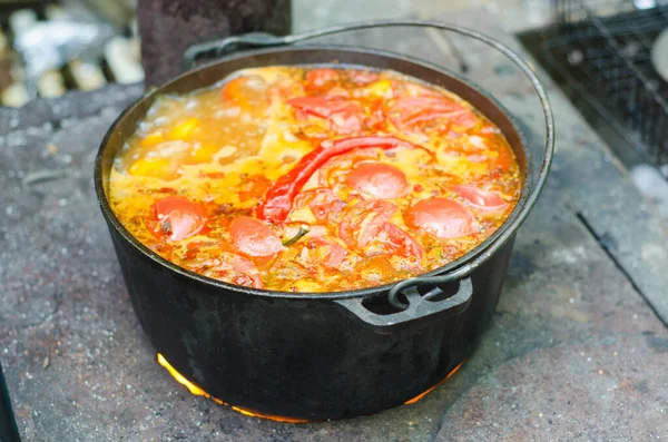 traditional soup cooking in cauldron