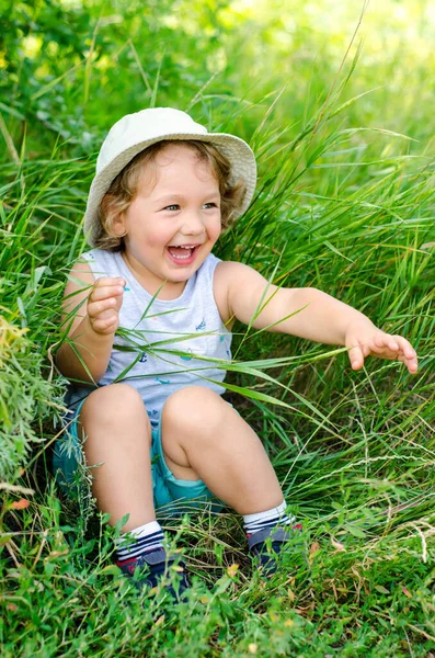 Glad Liten Pojke Sitter Ett Grönt Gräs — Stockfoto