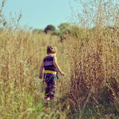 Kırsal alanda yürüyen küçük bir çocuk