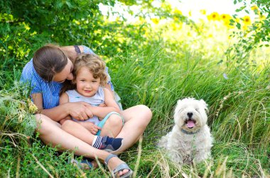 Anne ve çocuk çimenlerde oturuyor.