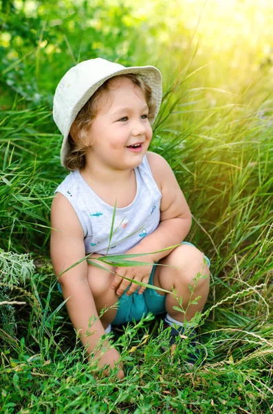 Glad Liten Pojke Sitter Ett Grönt Gräs — Stockfoto