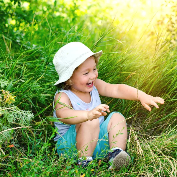 Glad Liten Pojke Sitter Ett Grönt Gräs — Stockfoto