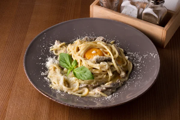 Makarna Carbonara beyaz plaka üzerinde