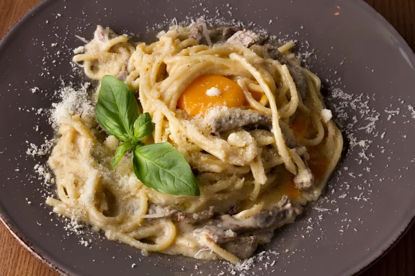 Makarna Carbonara beyaz plaka üzerinde