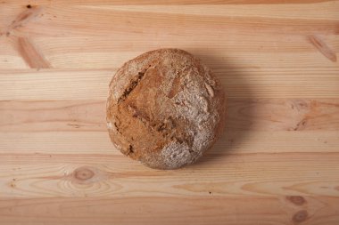 Sabah ışığında ahşap zemin üzerinde el yapımı taze buğday ekmeği. metin veya tasarım için boşluk alanı ile yatay çerçeve üst görünümü