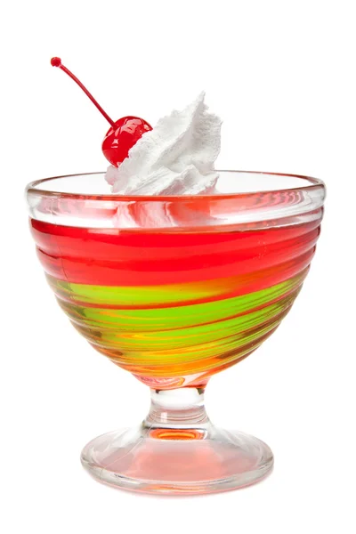 Многоцветный желейный десерт со взбитыми сливками и вишней — стоковое фото