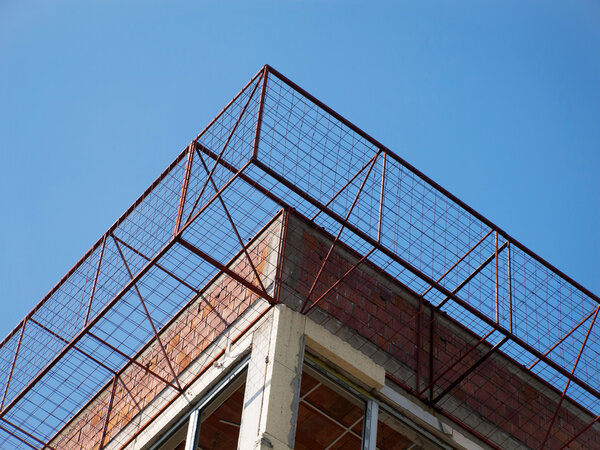 Metal wire cage on the unfinished building facade