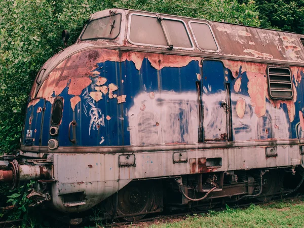 Alte Lokomotive auf den verlassenen Bahngleisen im Wald zurückgelassen — Stockfoto