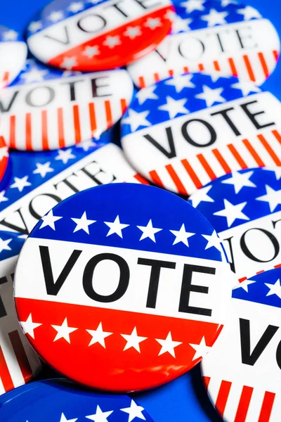 A group of red, white and blue VOTE button on a blue background — Stock Photo, Image