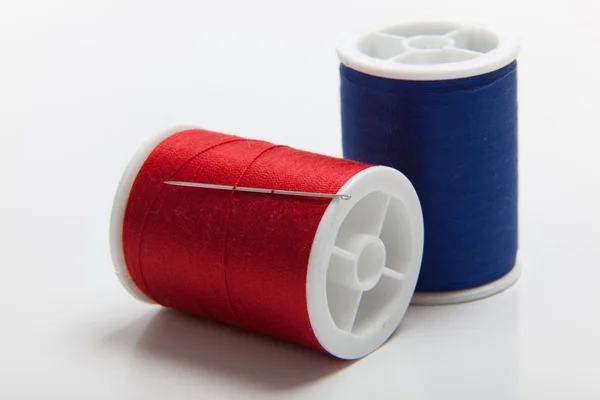Red and blue spools of sewing thread — Stock Photo, Image