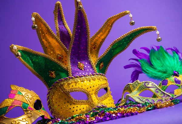 Różne mardi gras lub carnivale maska na fioletowym tle — Zdjęcie stockowe