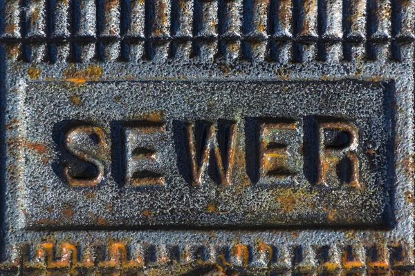 Sewer access cover with rusty iron — Stock Photo, Image