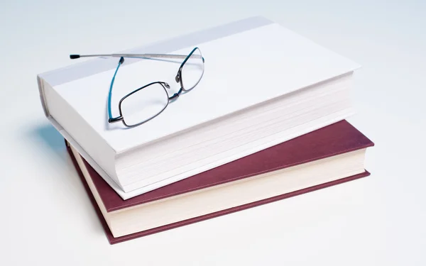 Bücher und Lesebrille auf Weiß — Stockfoto