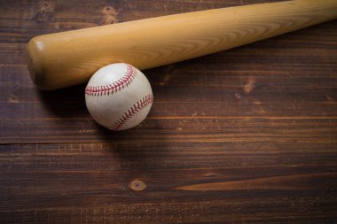 Bir tahta beysbol sopası ve ahşap arka plan üzerinde topu