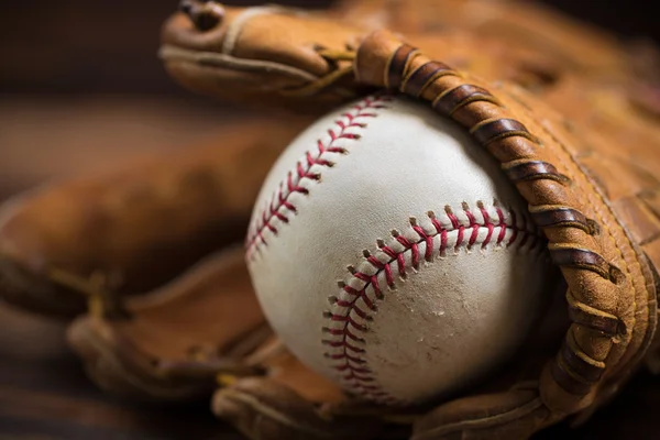 Baseballhandschuh und Ball aus Leder auf einer Holzbank — Stockfoto