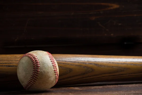 Una mazza da baseball in legno e palla su uno sfondo di legno — Foto Stock