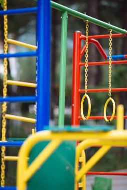 Zincirli sarı jimnastik yüzükleri ve merdivenleri olan çocuk parkı evi için renkli ekipman.