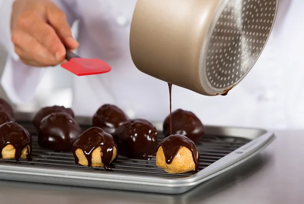 Szef kuchni dekorowanie niektóre profiteroles — Zdjęcie stockowe