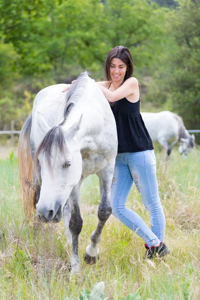 Mujer joven con su caballo — Foto de Stock