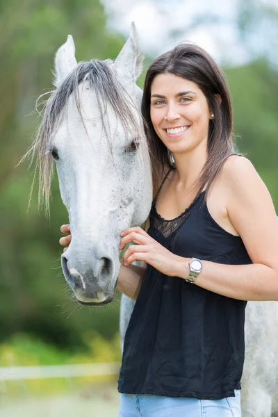 Jovem mulher com seu cavalo — Fotografia de Stock