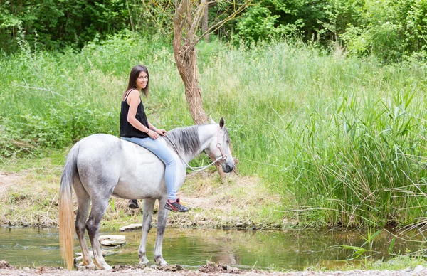 Jovem mulher com seu cavalo — Fotografia de Stock