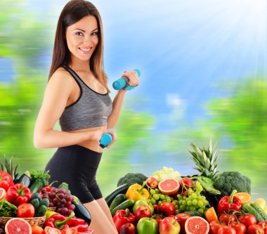 Çeşitli organik sebze ve meyveleri olan genç bir kadın.